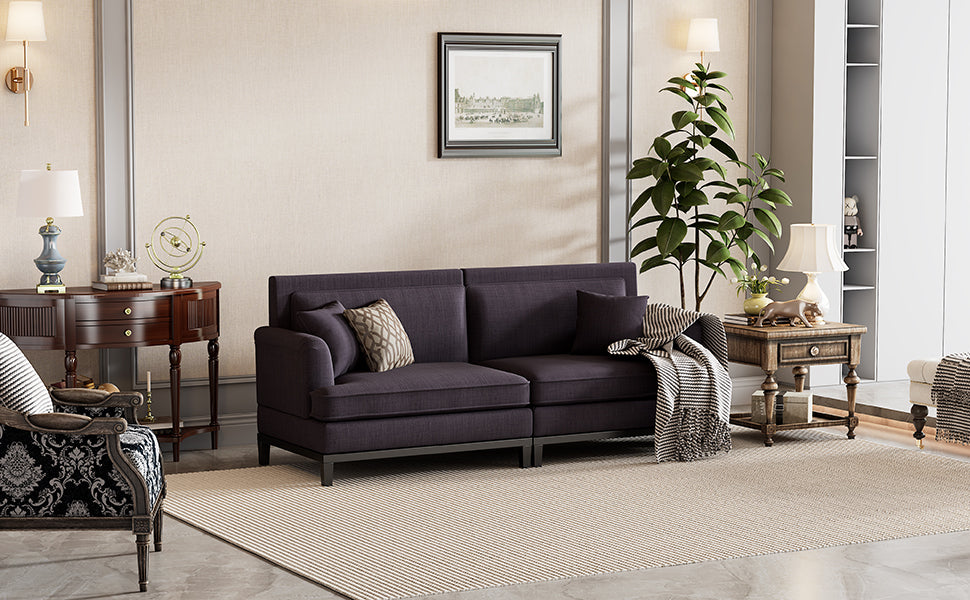 Sofá moderno tapizado en gris con patas de madera y dos cojines